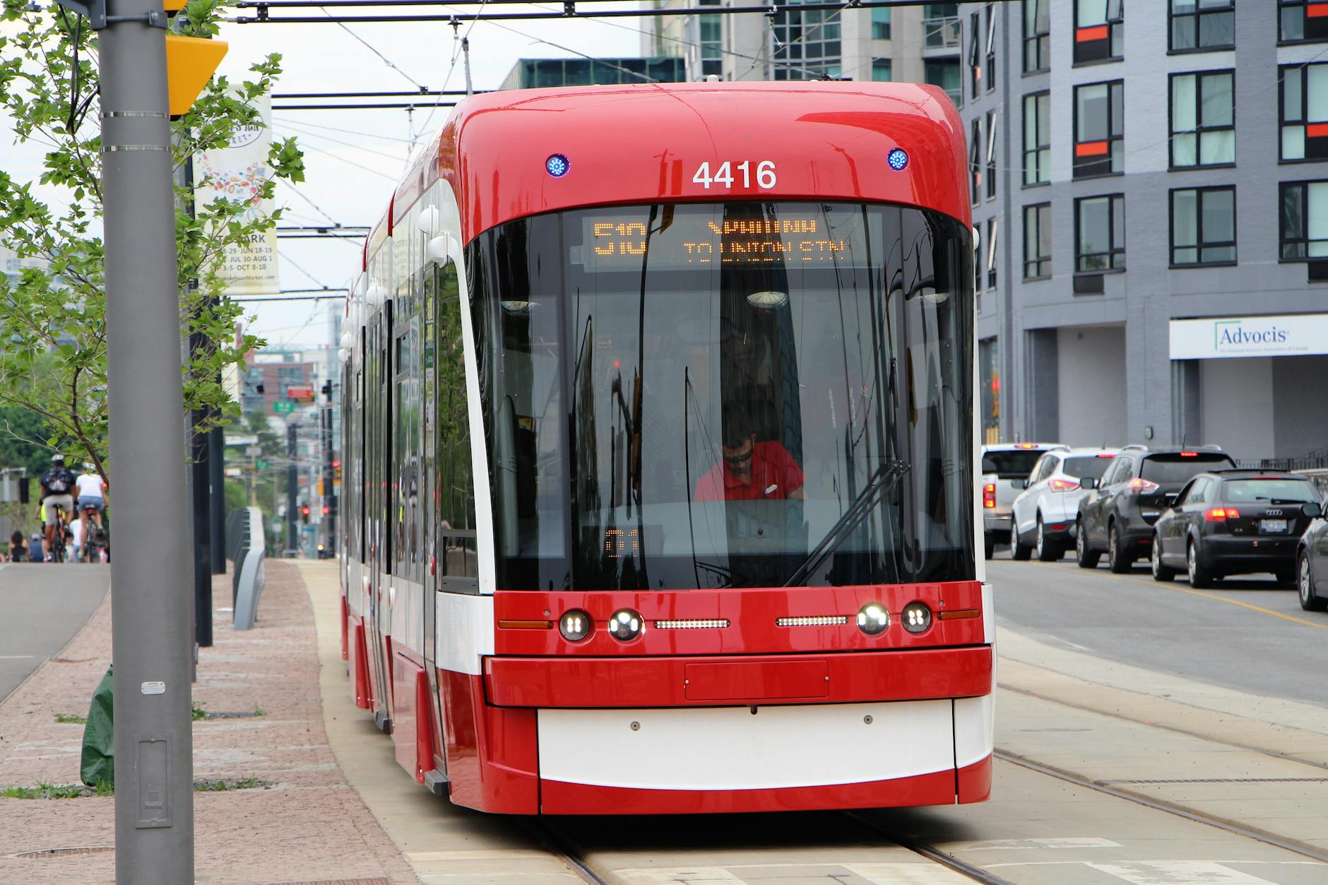 Red Toronto streetcar on a busy city route.