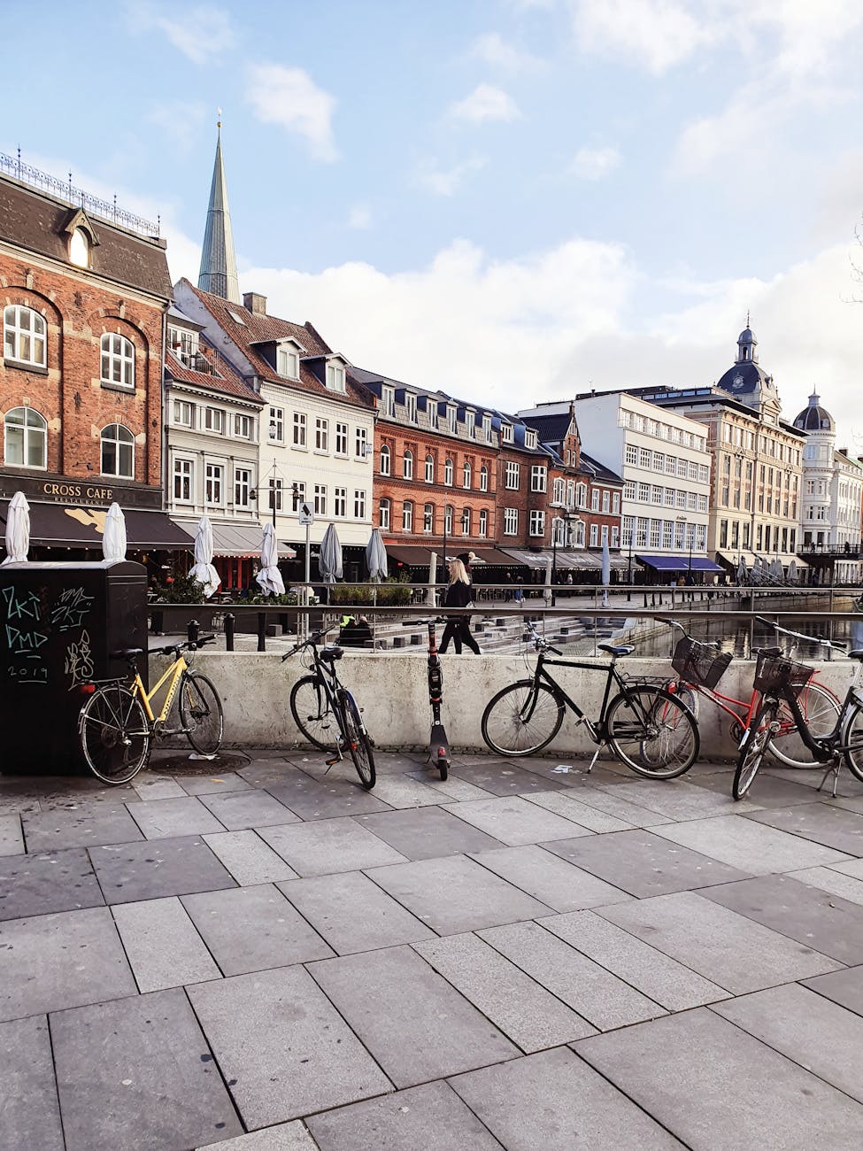 Bicycles lining a lively street in Aarhus.