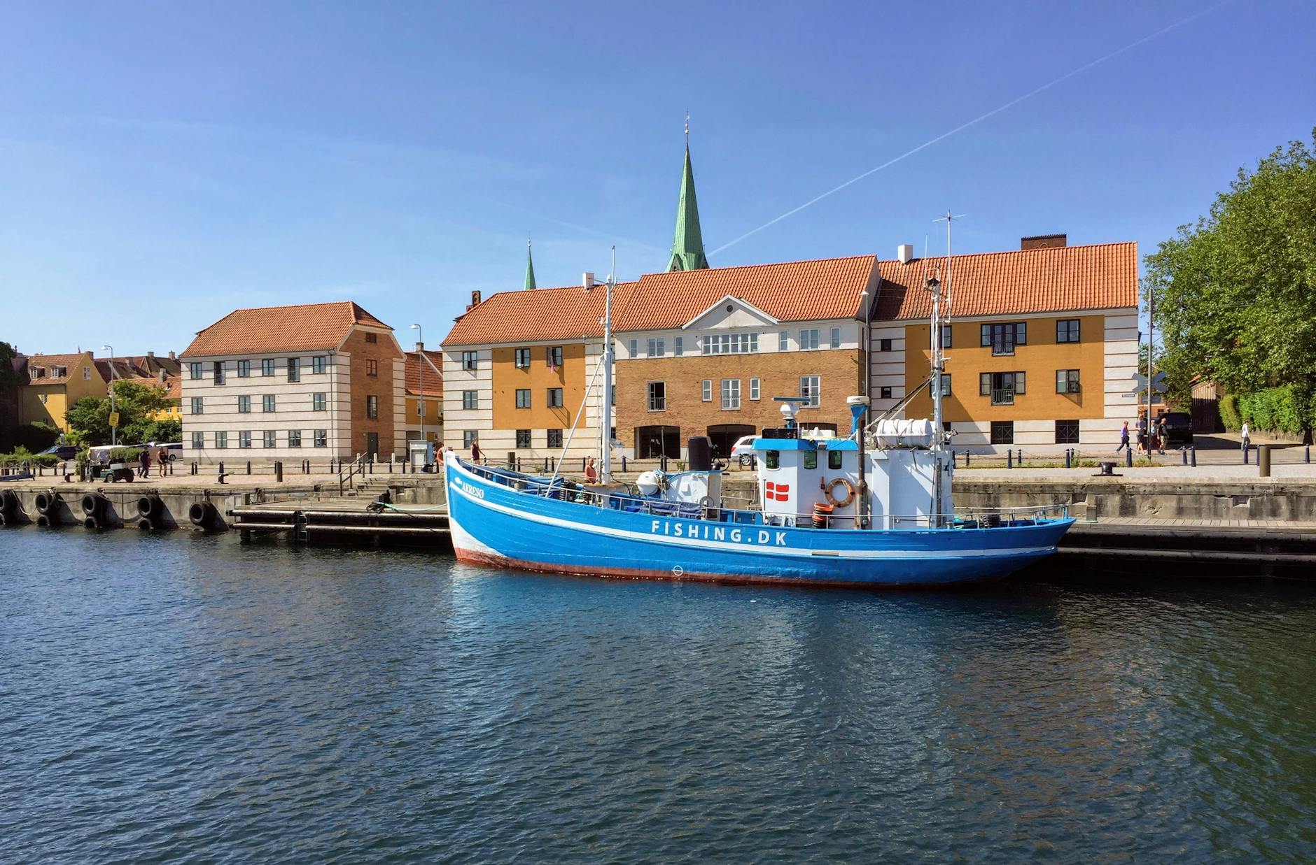 Harbor scene in Elsinore with a blue boat and historic buildings.