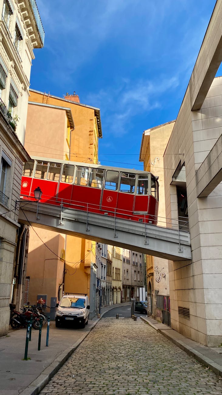 Red funicular crossing between buildings in Lyon.