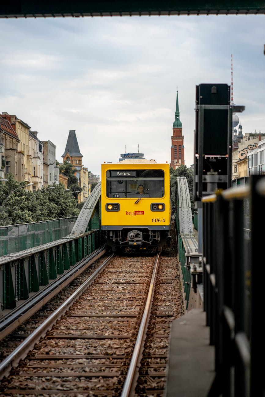 Yellow U-Bahn train on elevated track in Berlin.