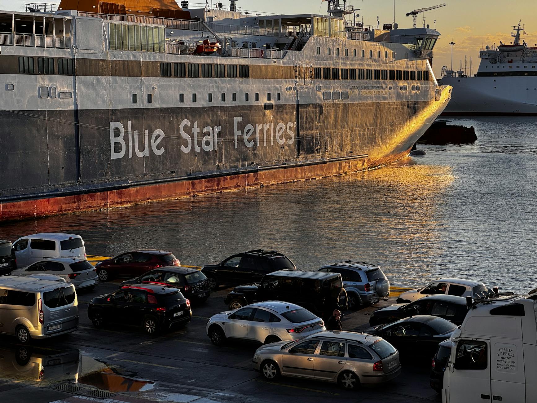 Blue Star Ferry docked at Athens port during sunset.
