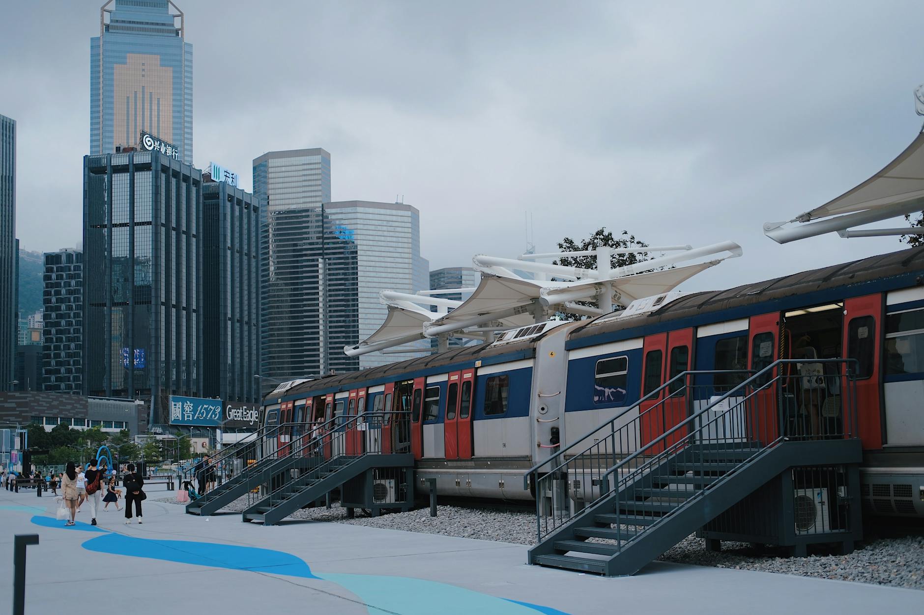 Urban rail platform framed by Hong Kong skyscrapers.
