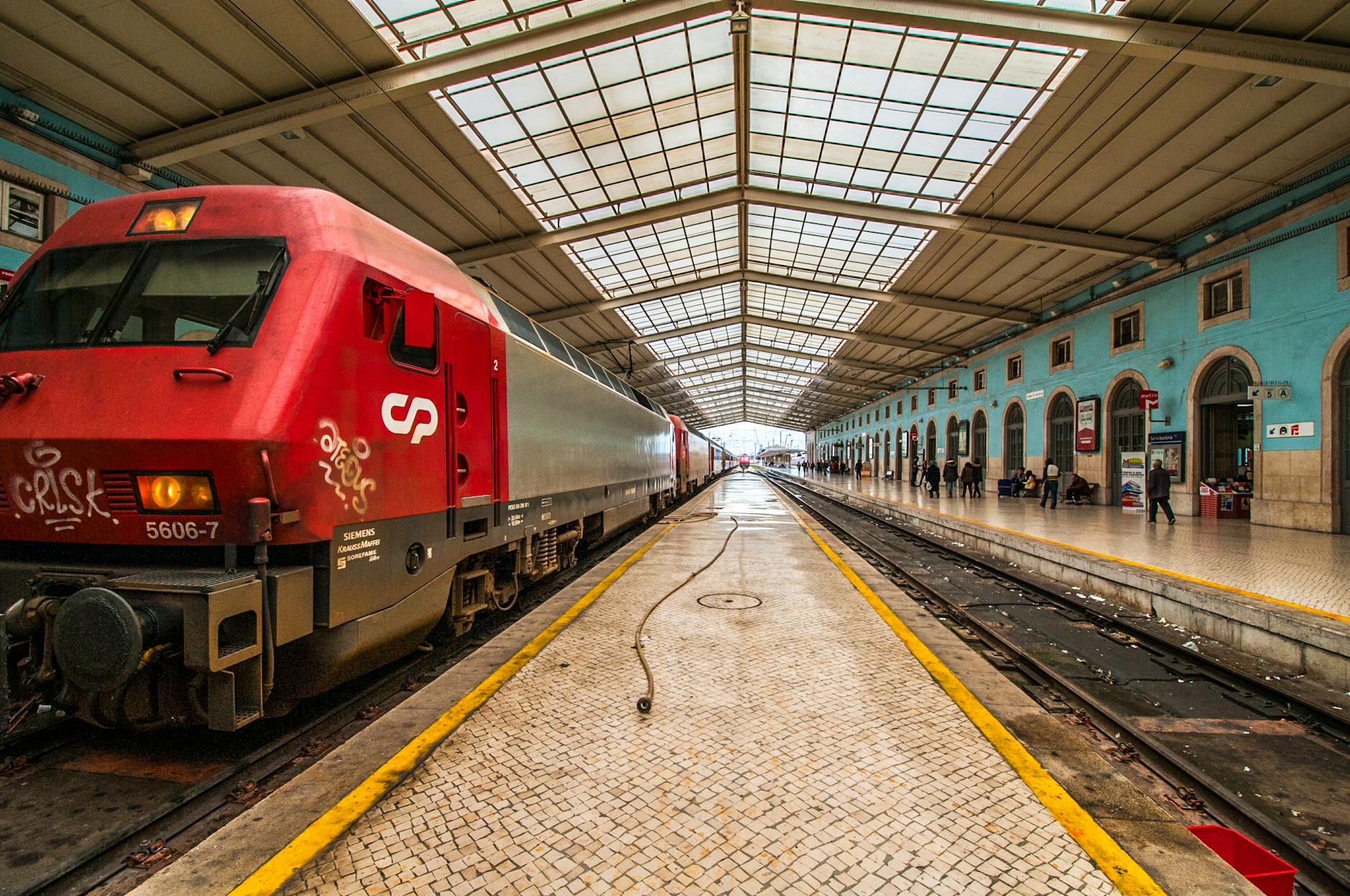 Red passenger train at Rossio station in Lisbon.