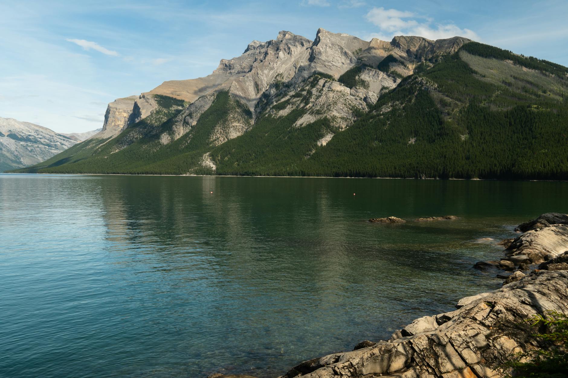 Serene lake and rocky mountains in Banff, Alberta. Perfect for nature photography lovers.