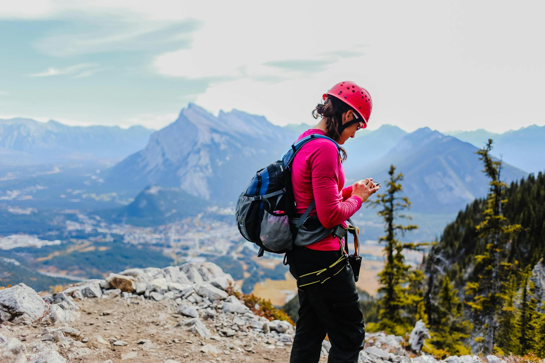 Woman in gear exploring rugged mountains with scenic views and vibrant colors.