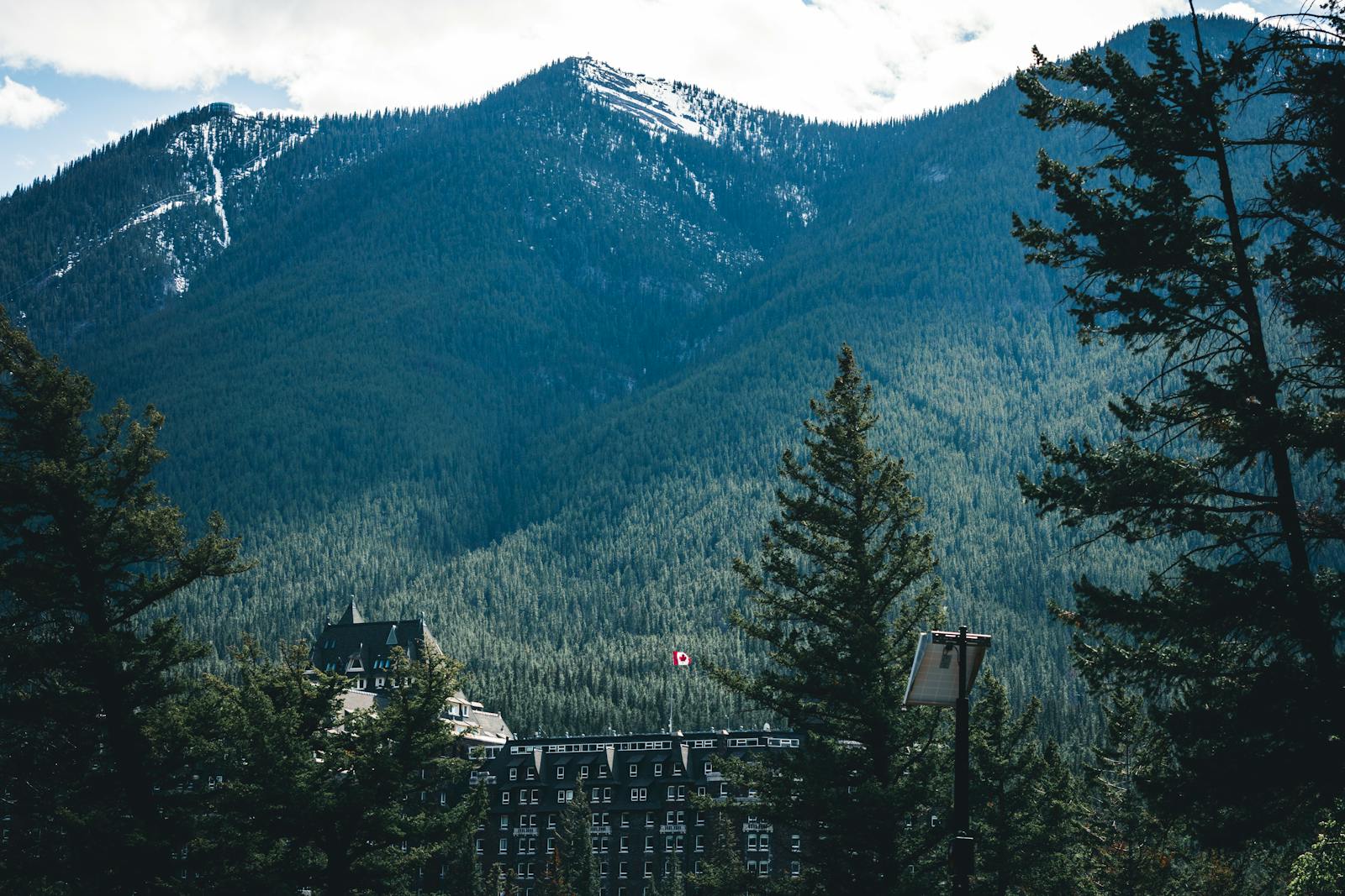 Banff Springs Hotel nestled among mountains and trees in Banff, Alberta.