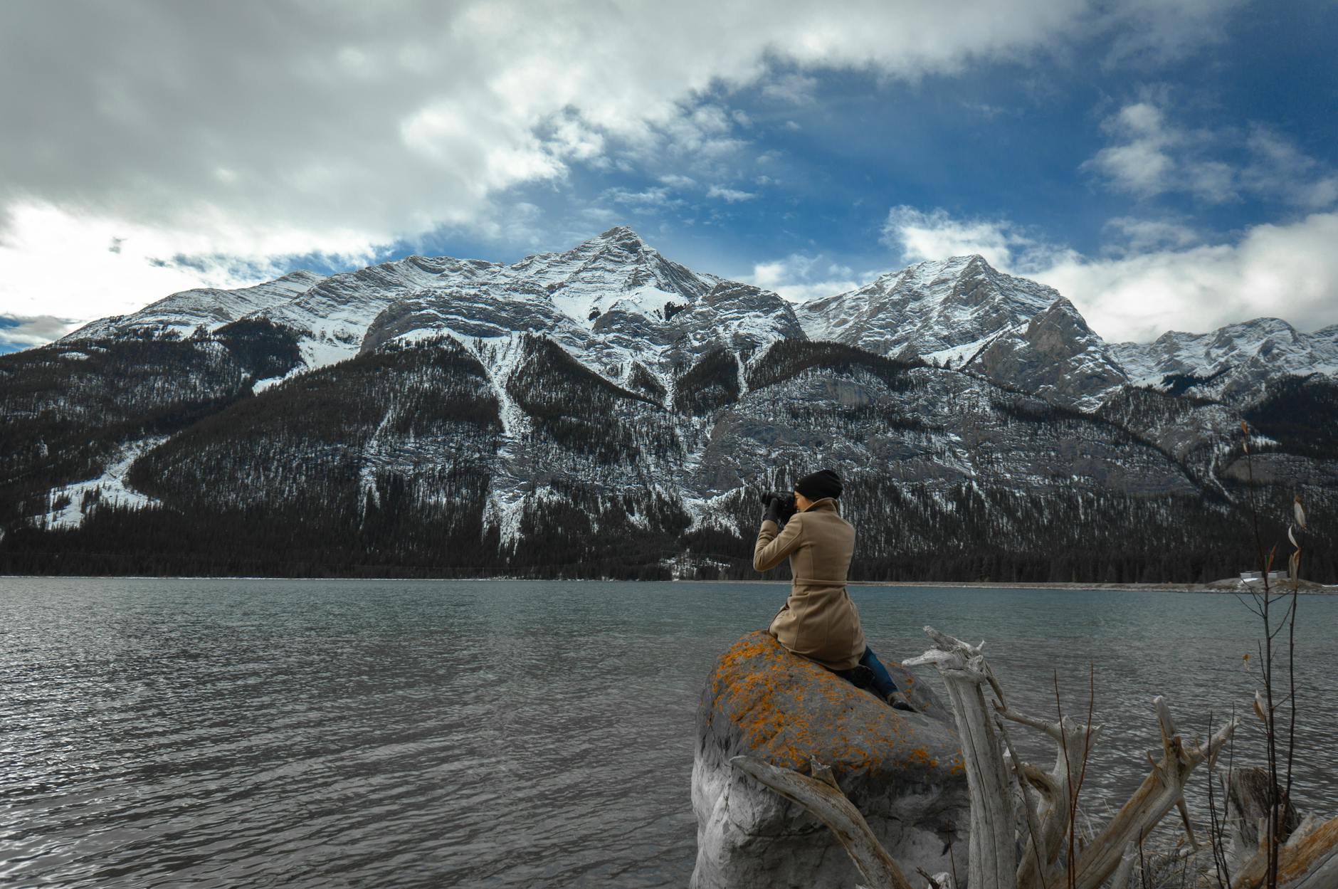 Photographer focuses on a stunning snow-covered mountain landscape at a serene lake in Canada.