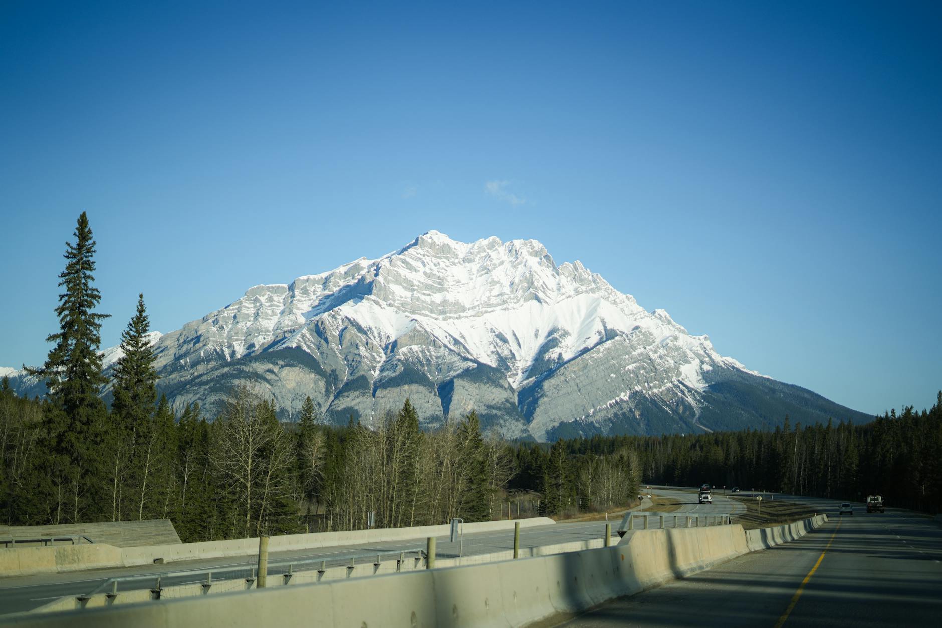 Captivating snow-capped mountain scene captured from a highway in Banff National Park during winter.