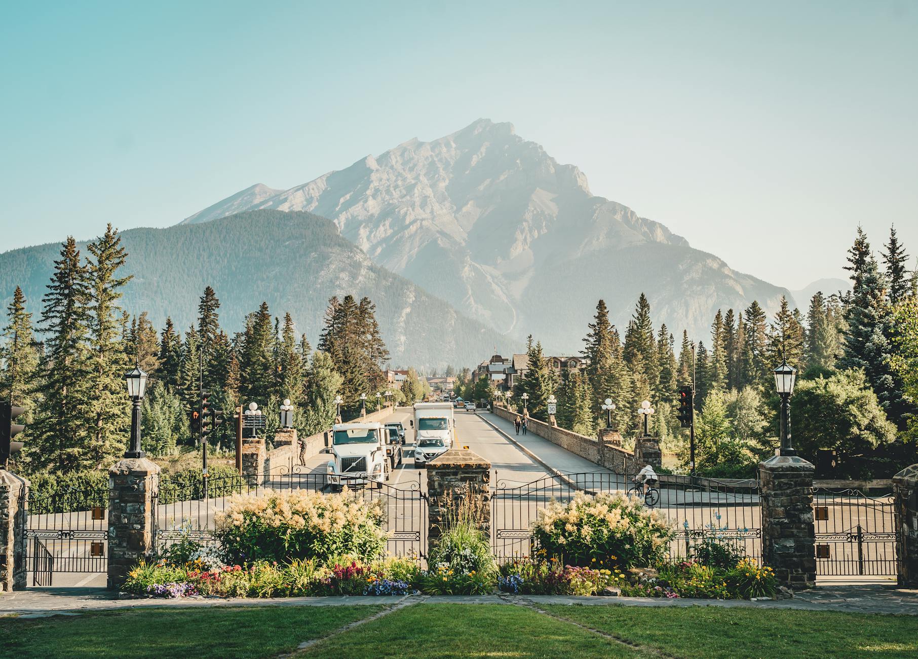 A picturesque view of Banff Avenue with a stunning mountain backdrop, showcasing nature and urban life.