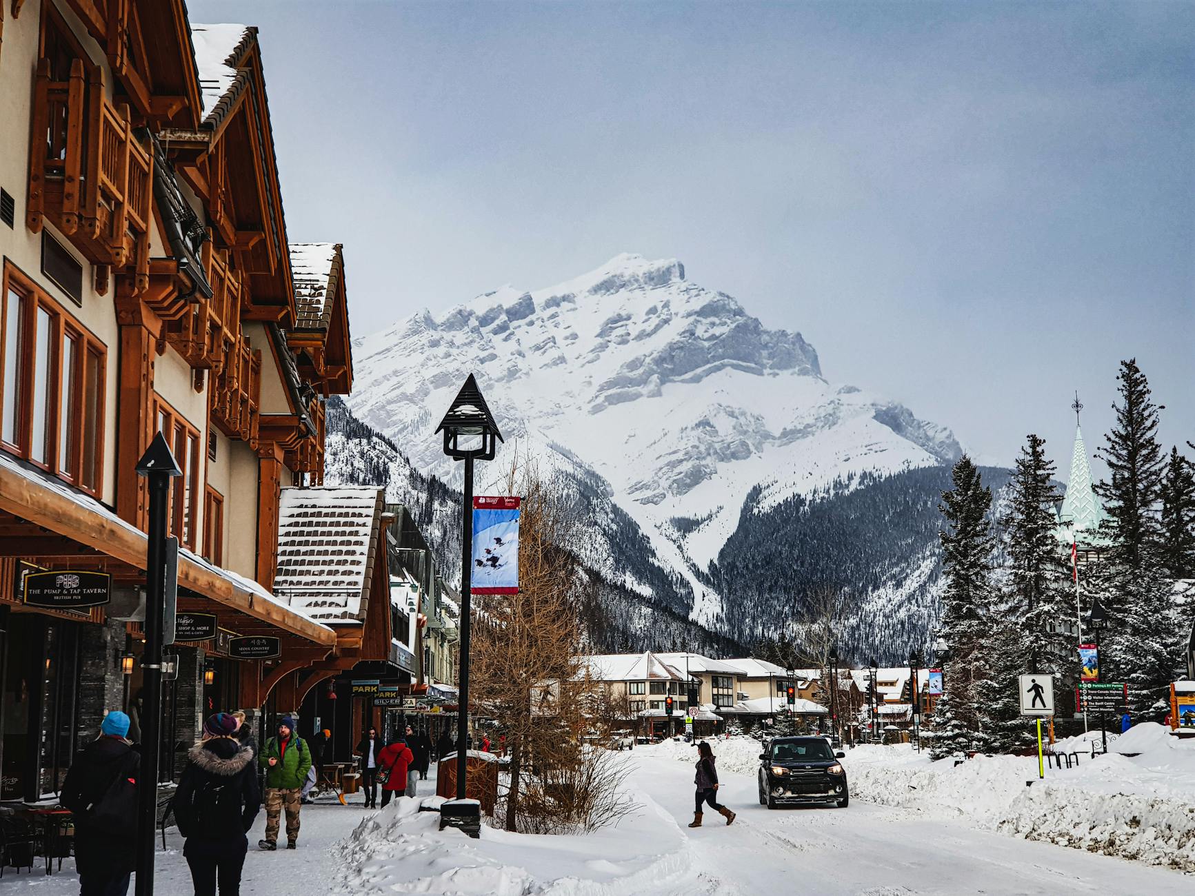Charming winter landscape in Banff with snow-covered mountains and town streets.