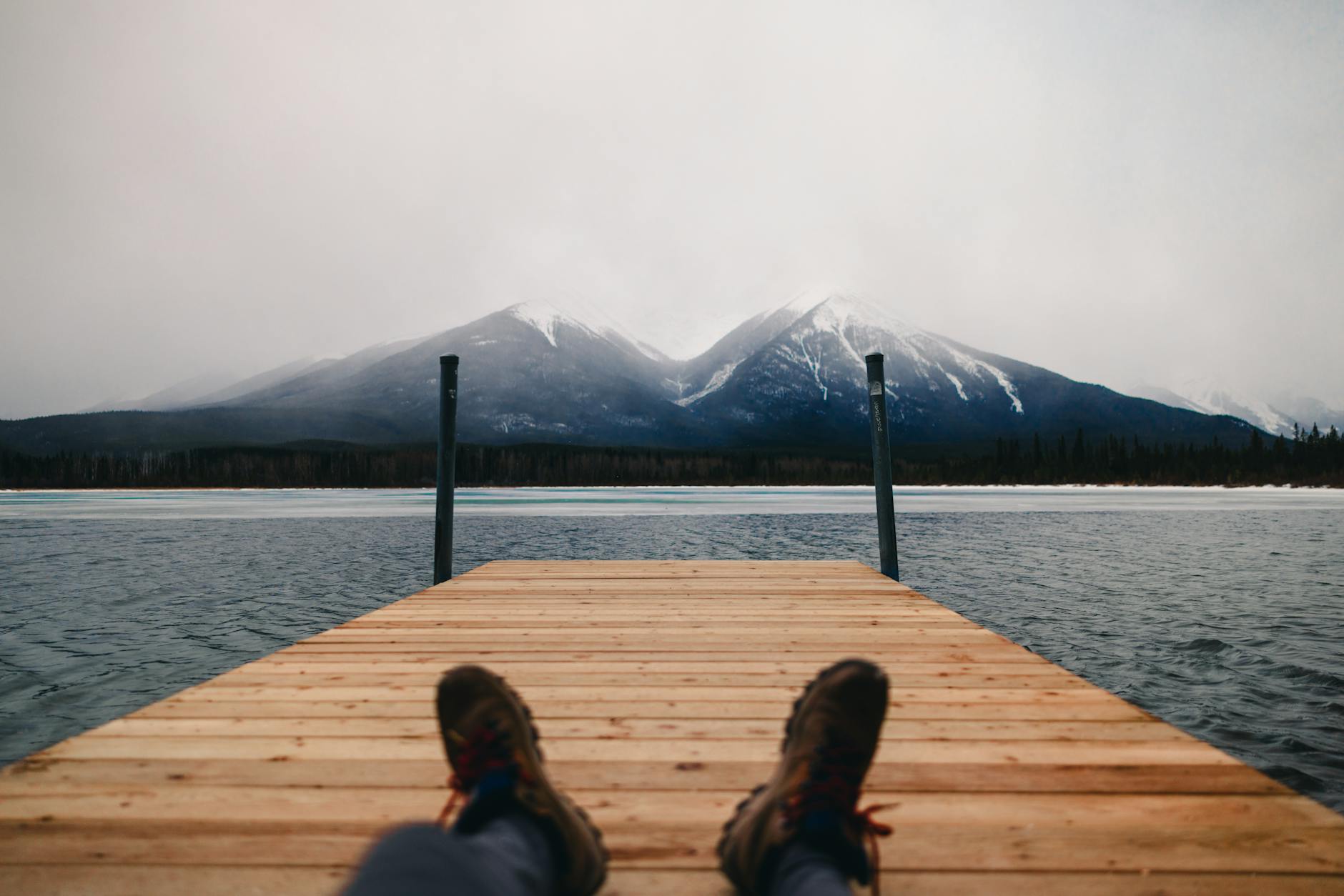 Peaceful moment on a dock overlooking snow-capped mountains in Banff, Canada.