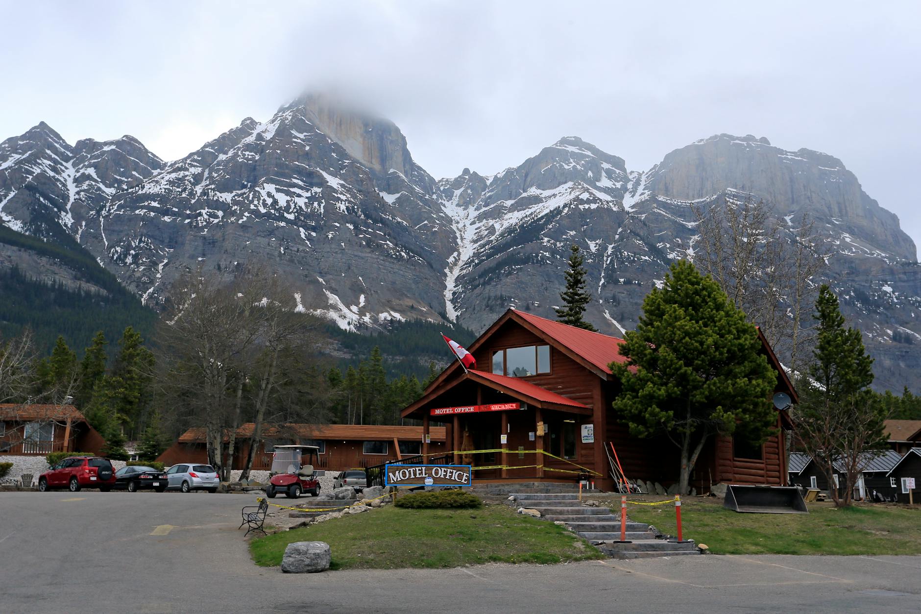 Mountain lodge with snowy peaks in the background, offering a rustic getaway vibe.