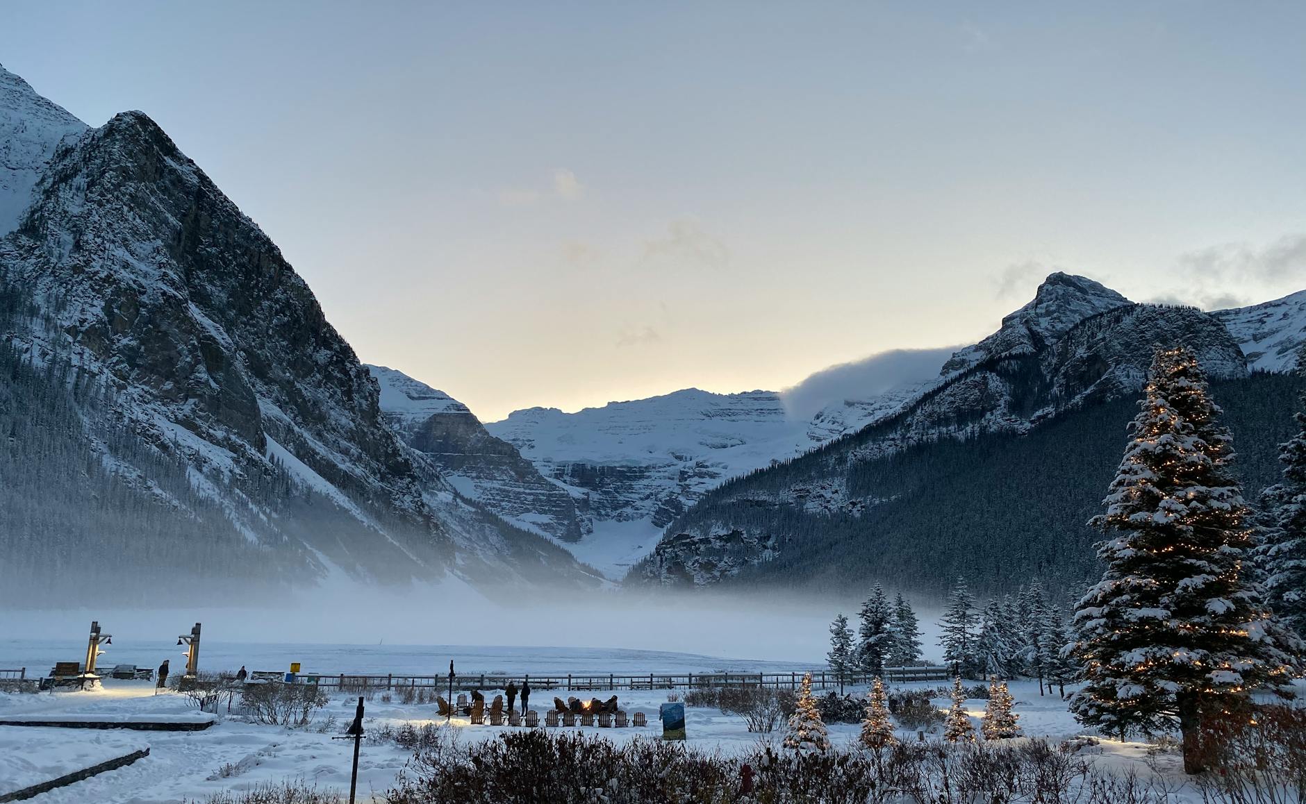 Beautiful winter landscape at Lake Louise with snowy mountains and a foggy atmosphere.