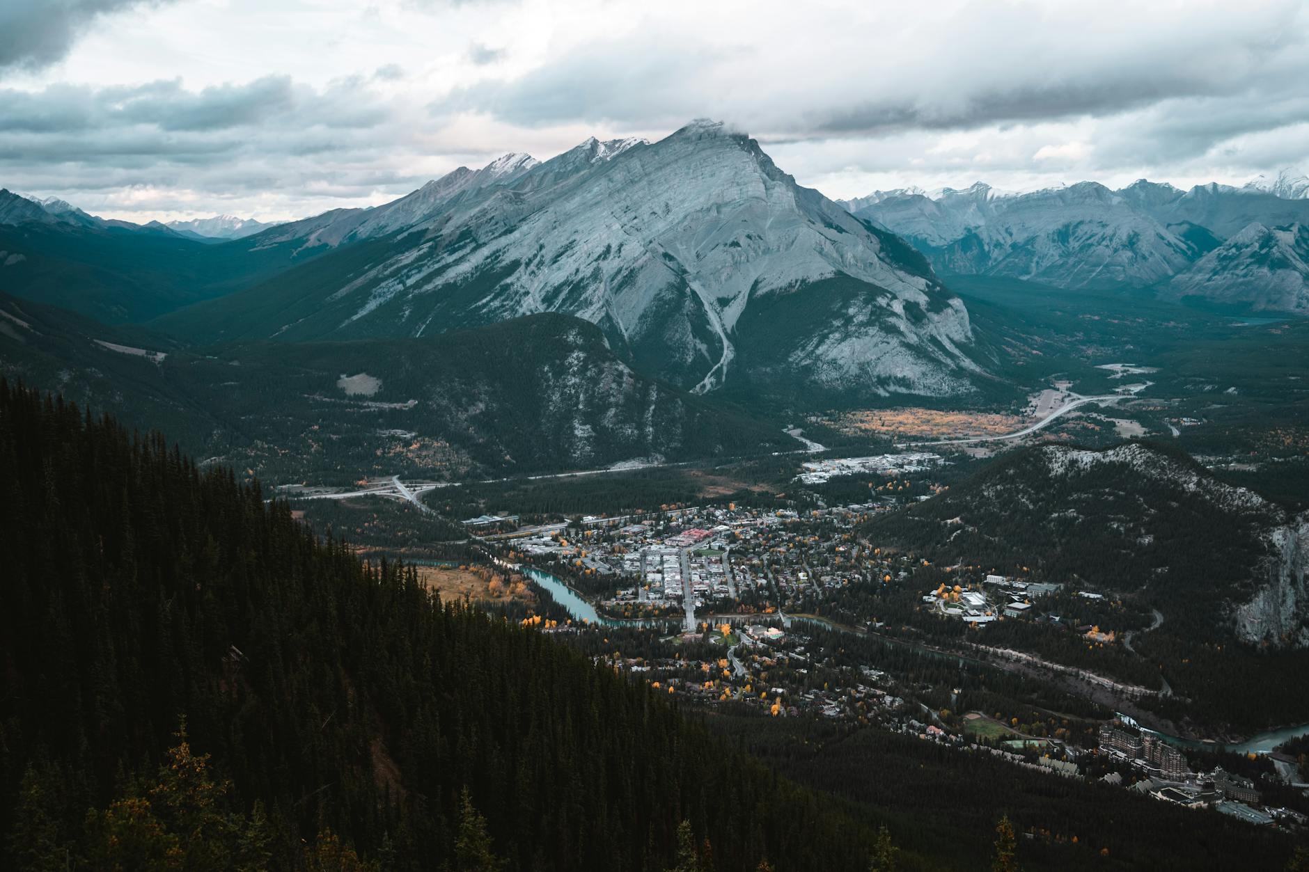 A breathtaking aerial view of a mountain town nestled in a scenic valley surrounded by towering peaks.