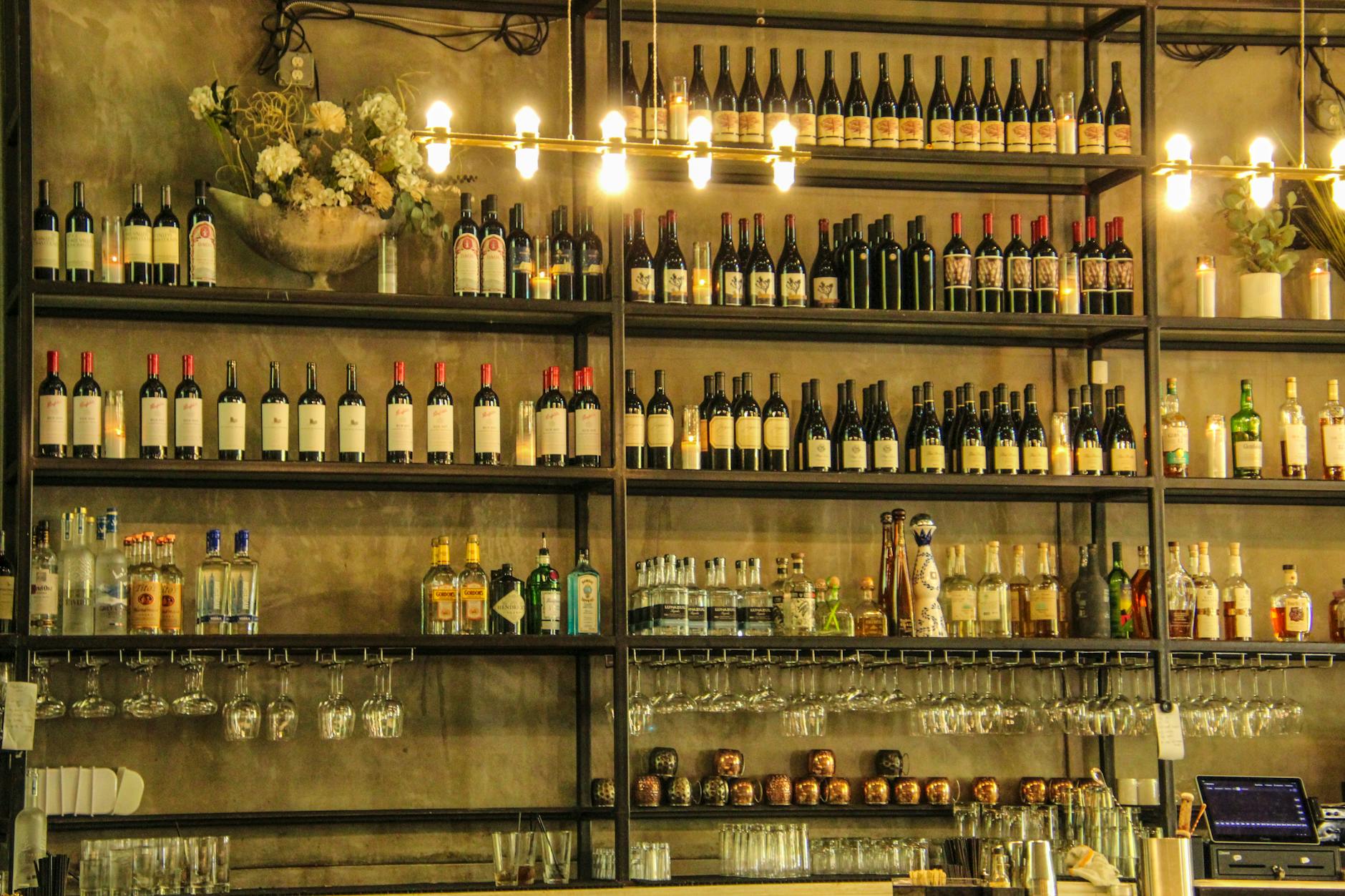 A stylish bar shelf filled with assorted wine and liquor bottles, elegantly arranged for a sophisticated ambiance.