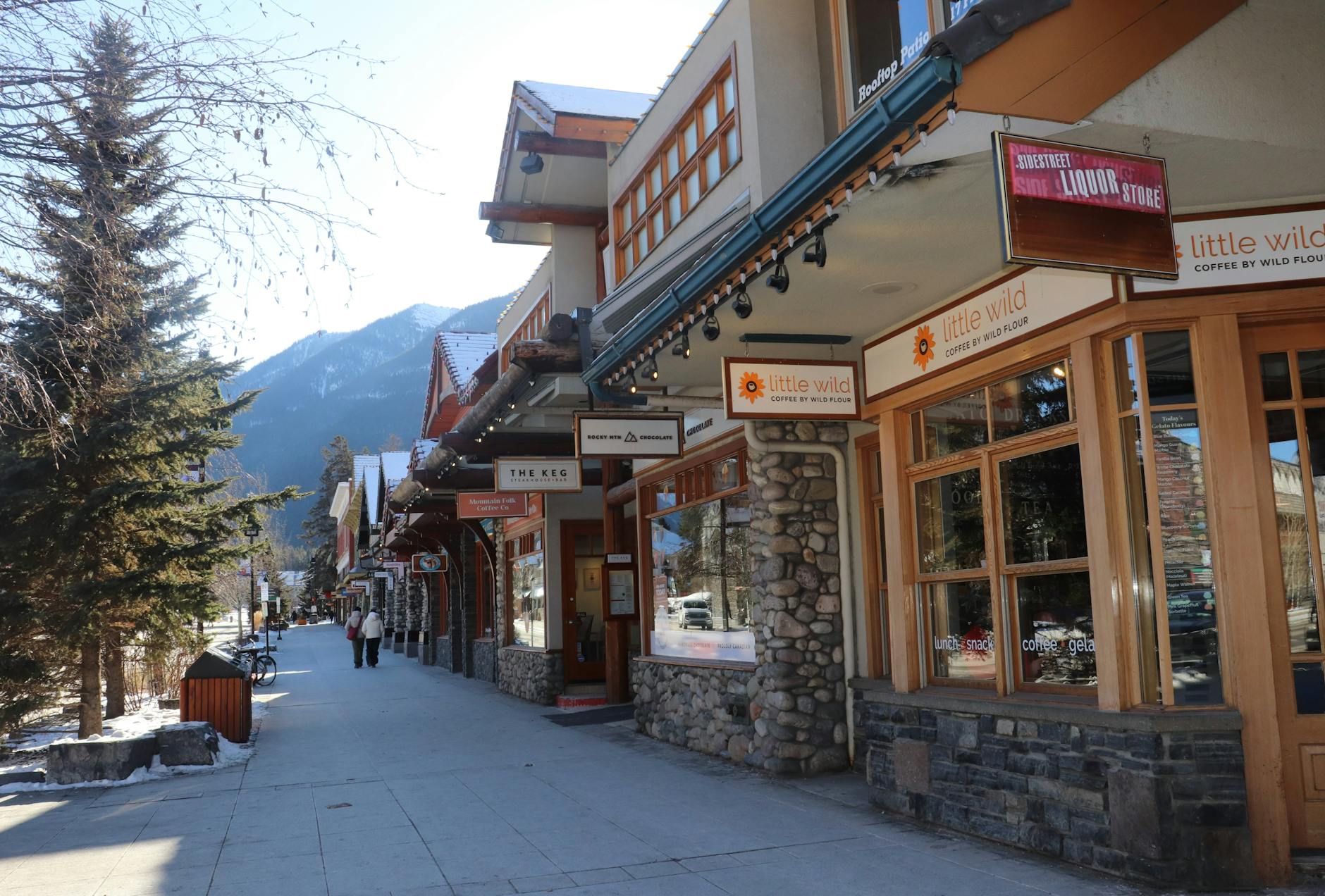 A scenic street view in Banff with shops, showing mountains in the backdrop. Ideal for travel enthusiasts.