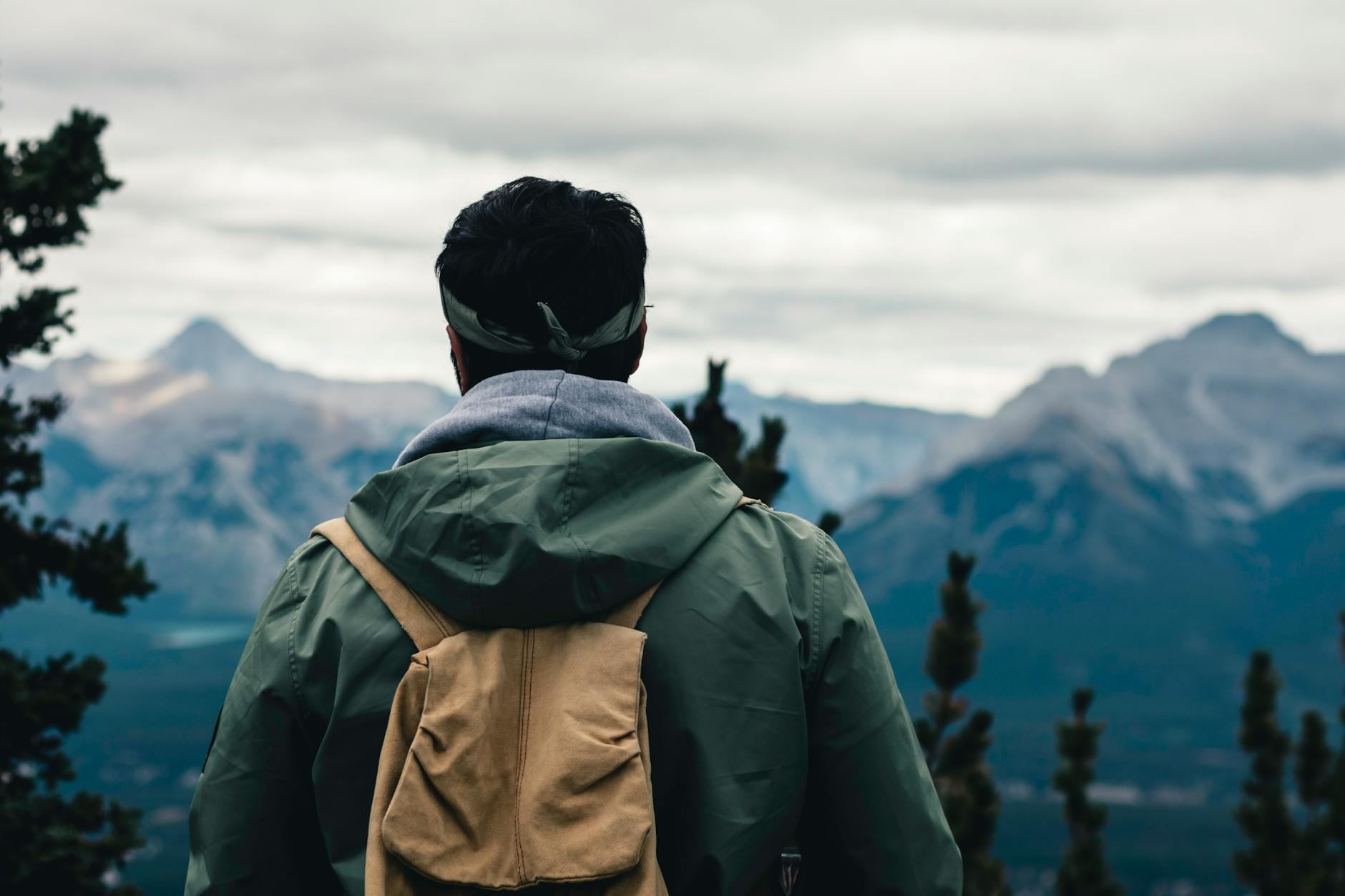 A man with a backpack enjoys the scenic mountain view in Banff National Park, Canada.