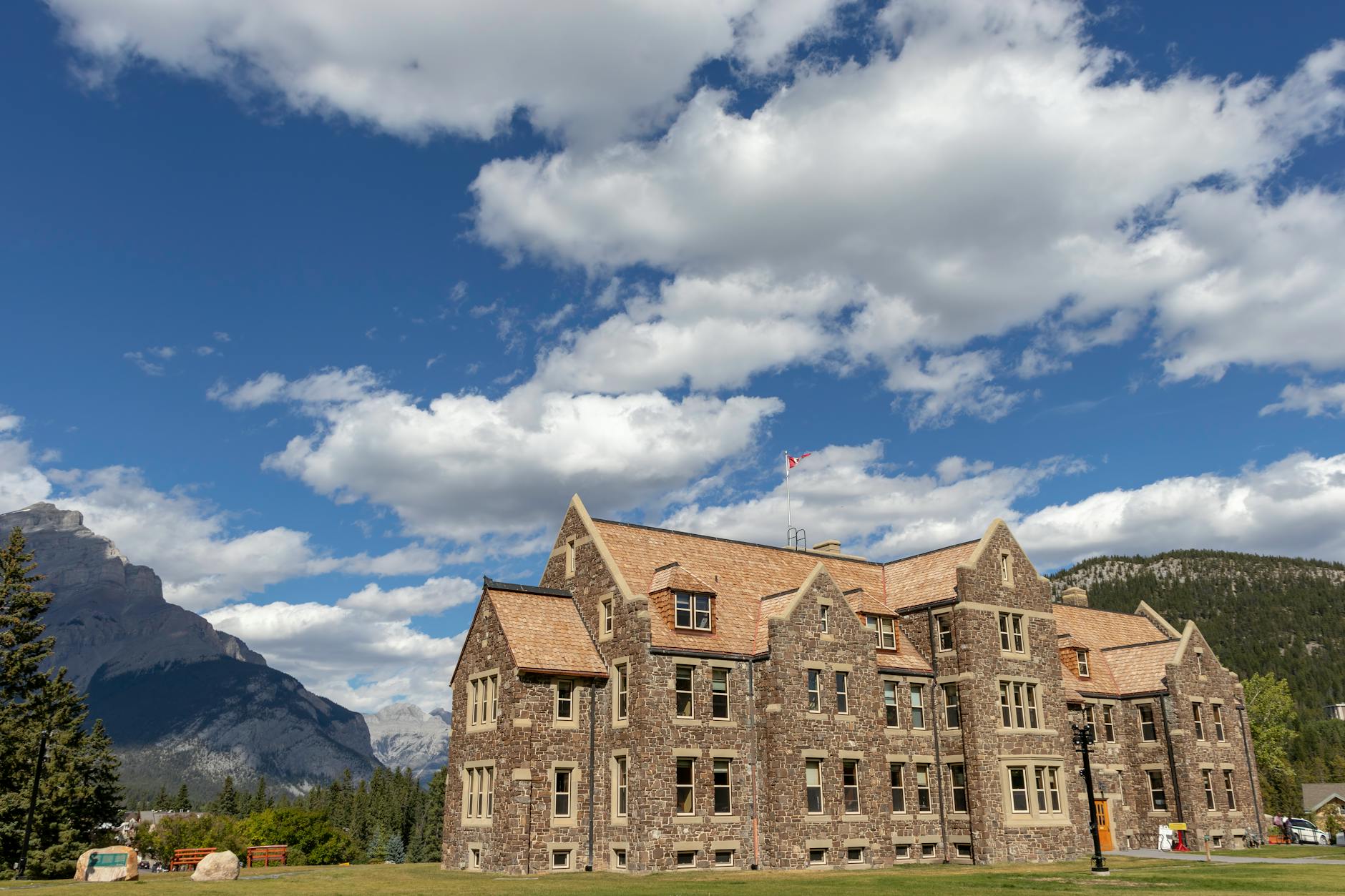 Historic stone building set against a mountain backdrop in Banff, Canada.