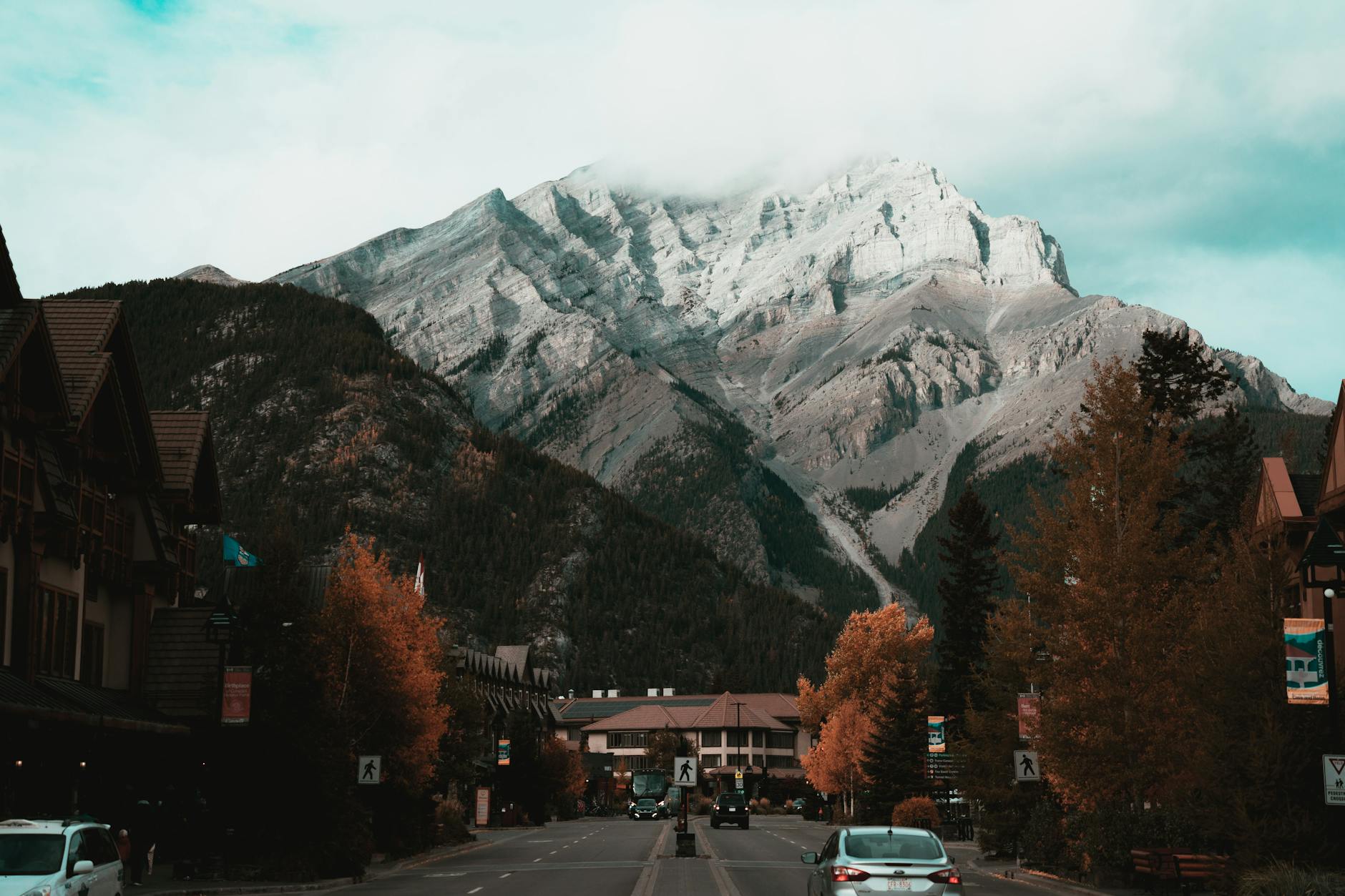 Picturesque Banff, Canada with mountains and autumn trees lining the road.