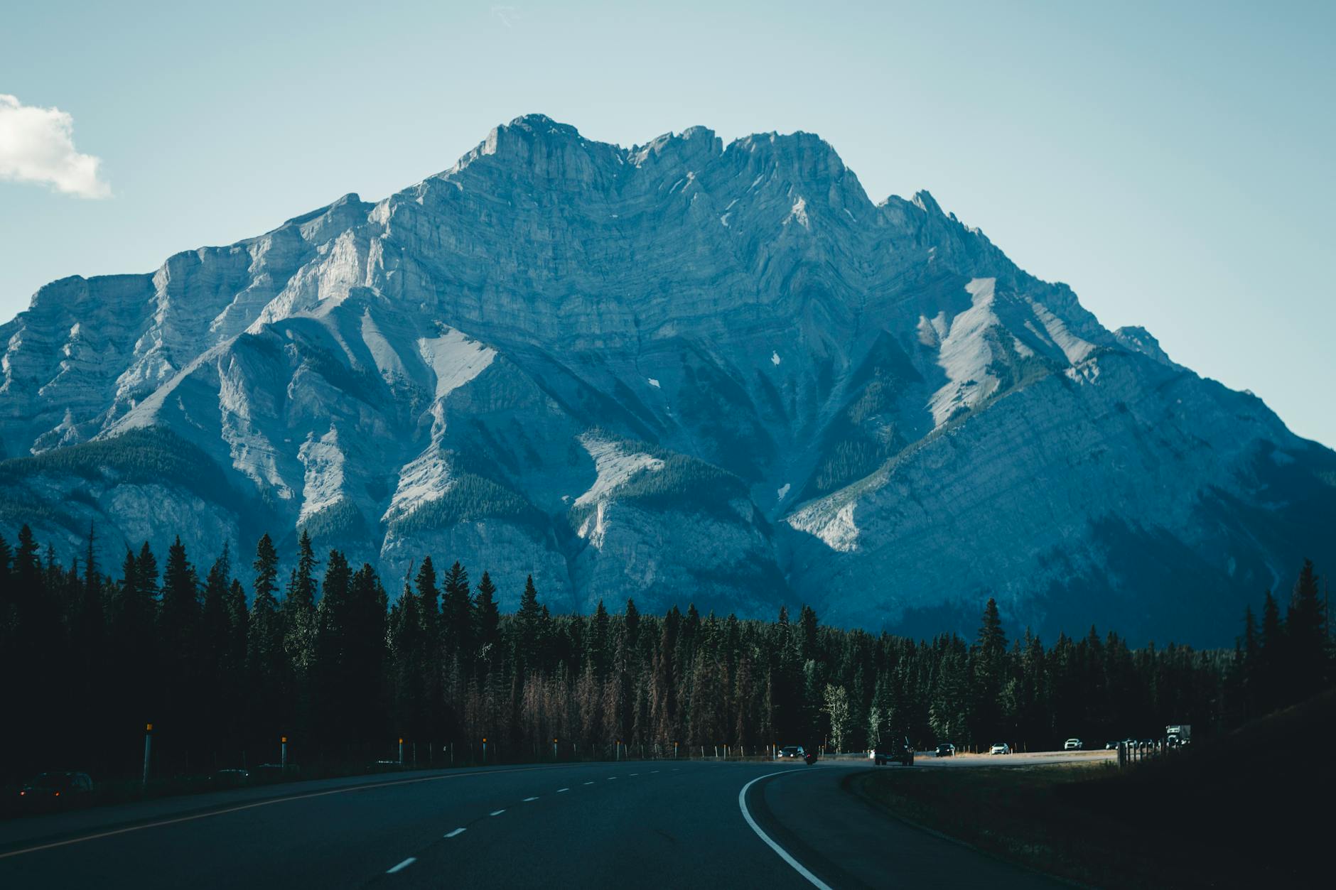 A picturesque view of the road winding towards the majestic Rocky Mountains in Banff, Canada.