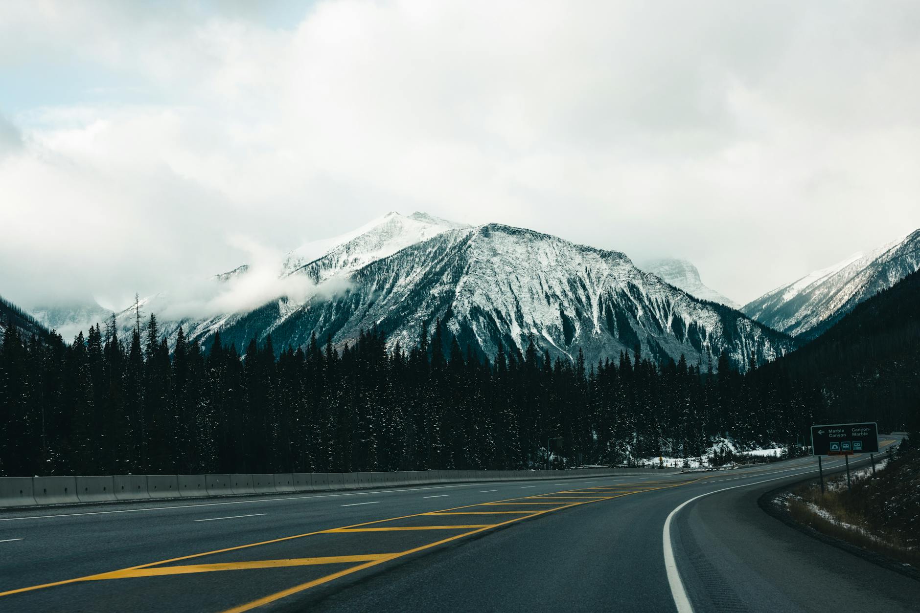 Explore a scenic road winding through snow-capped mountains in Banff, Canada, perfect for winter adventures.