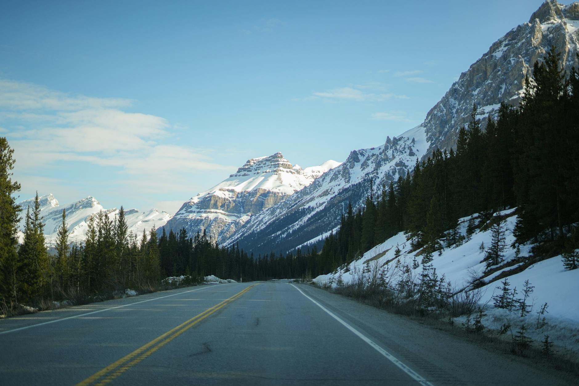 Beautiful snow-capped mountains and winding road in Banff National Park, perfect for travel and nature enthusiasts.