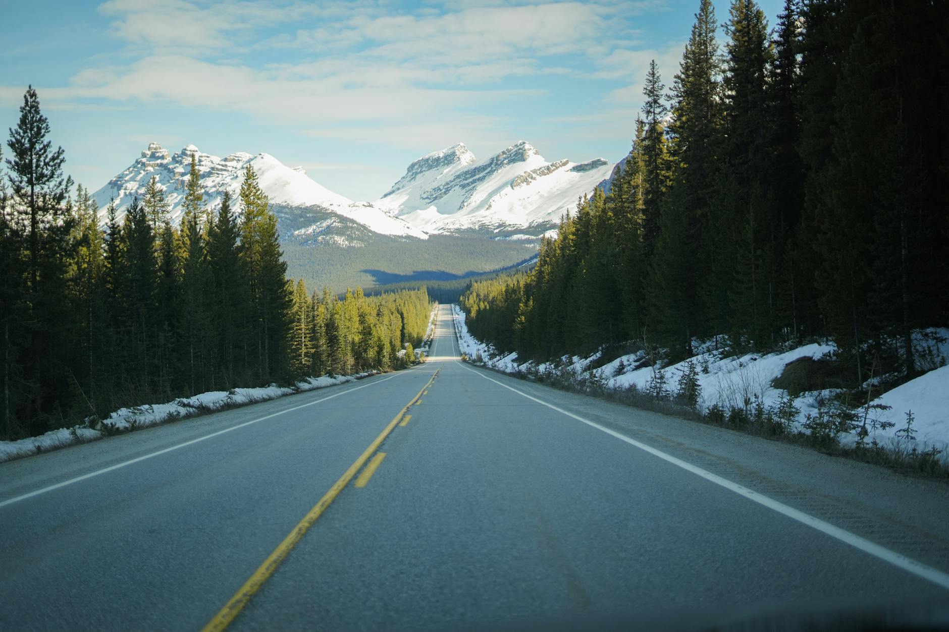 Explore a stunning mountain view with a clear road leading through Banff National Park.