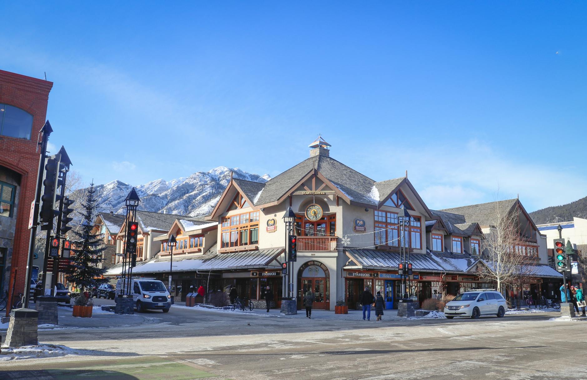 Bright winter day in downtown Banff with mountain backdrop and charming architecture.