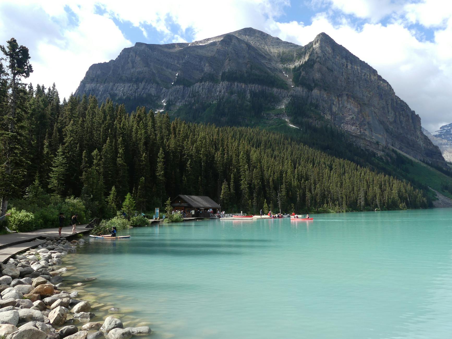 Peaceful view of Lake Louise with canoe rentals and Rocky Mountains in Banff National Park.