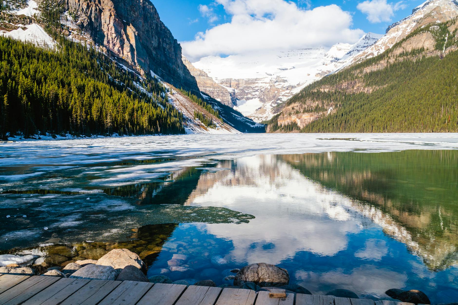 A breathtaking view of Lake Louise with snowy mountains reflecting in the water.