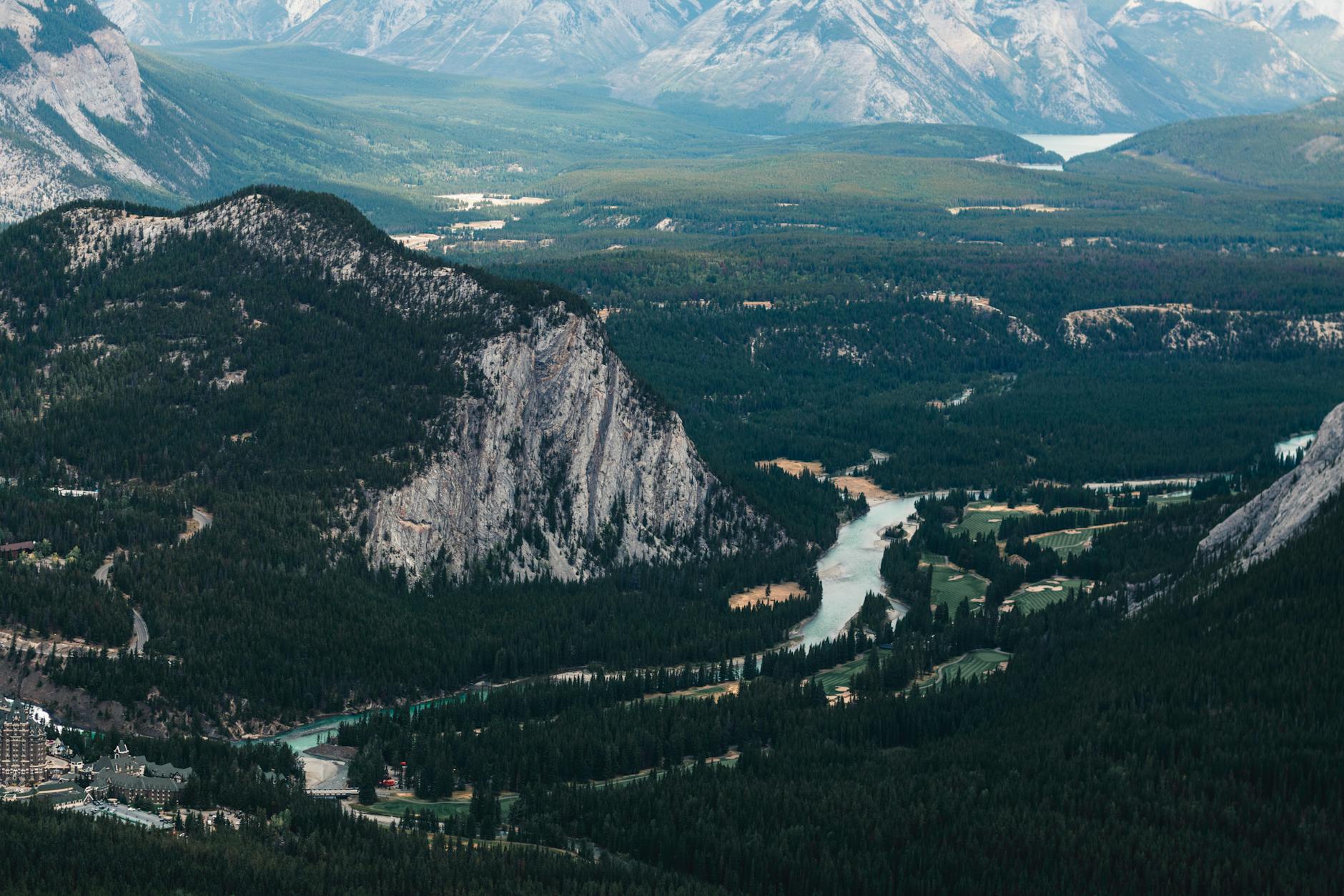 A breathtaking aerial view of the valley in Banff National Park, showcasing the river and lush forests.