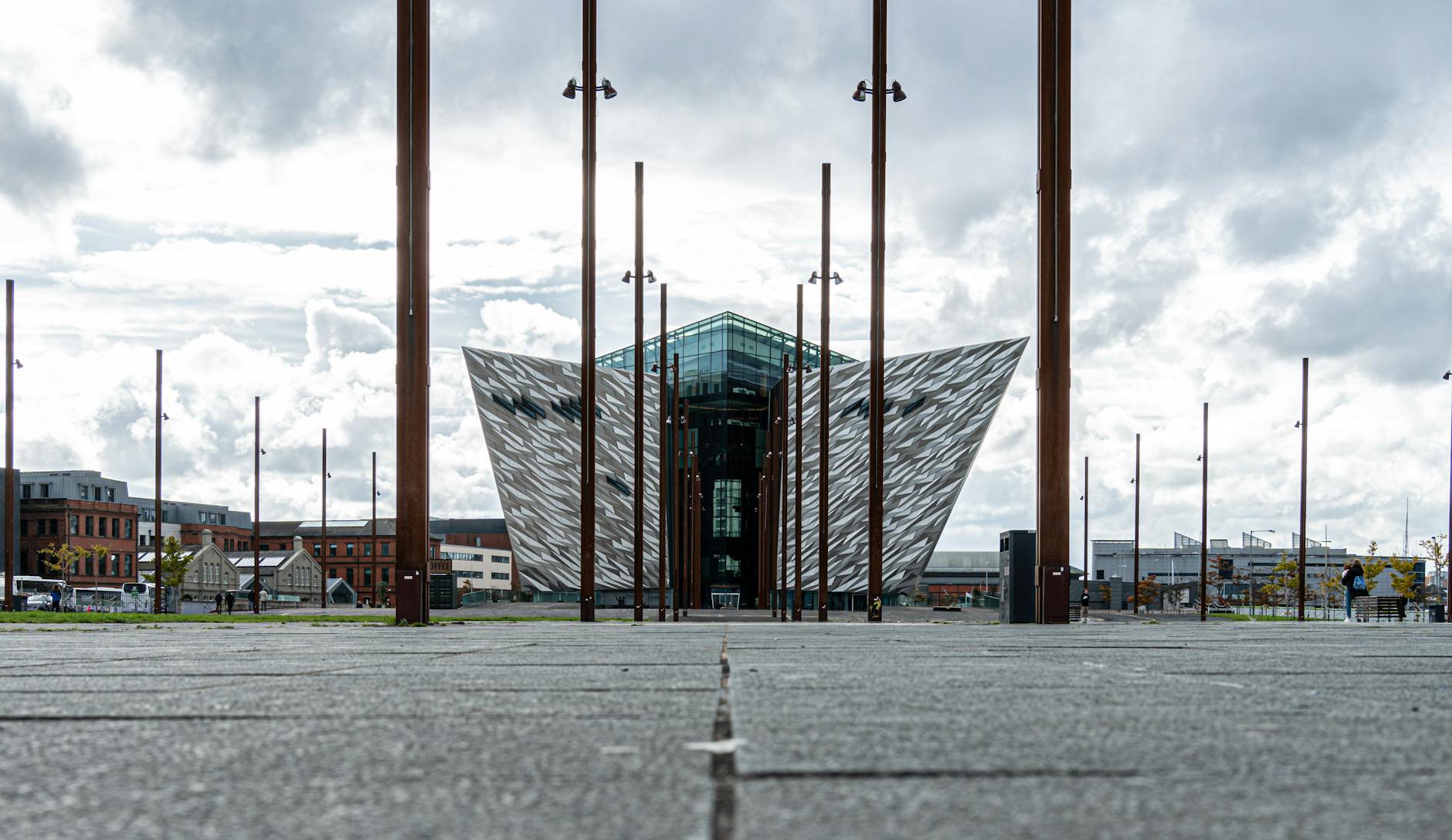 The striking modern architecture of Titanic Belfast under a cloudy sky.