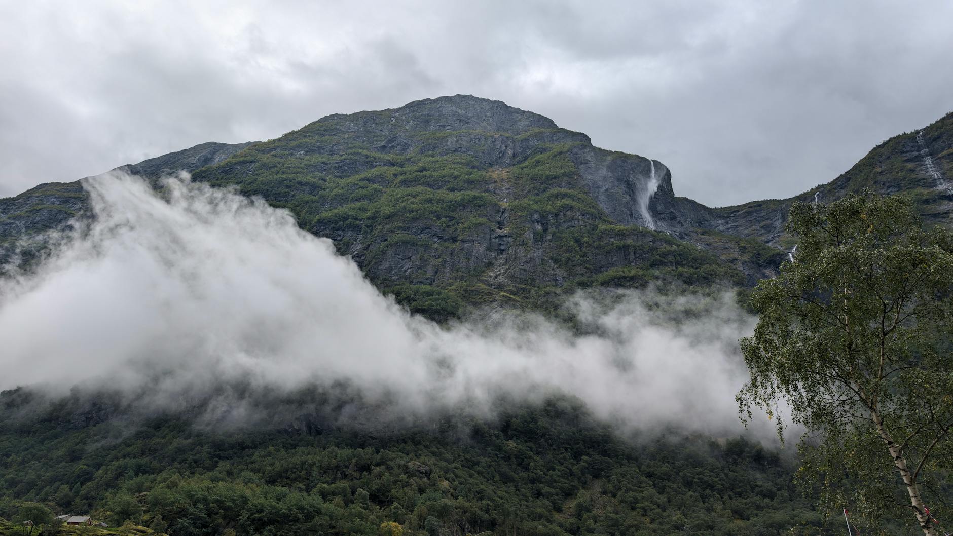 Clouds over green Bergen mountains for outdoor travel planning.