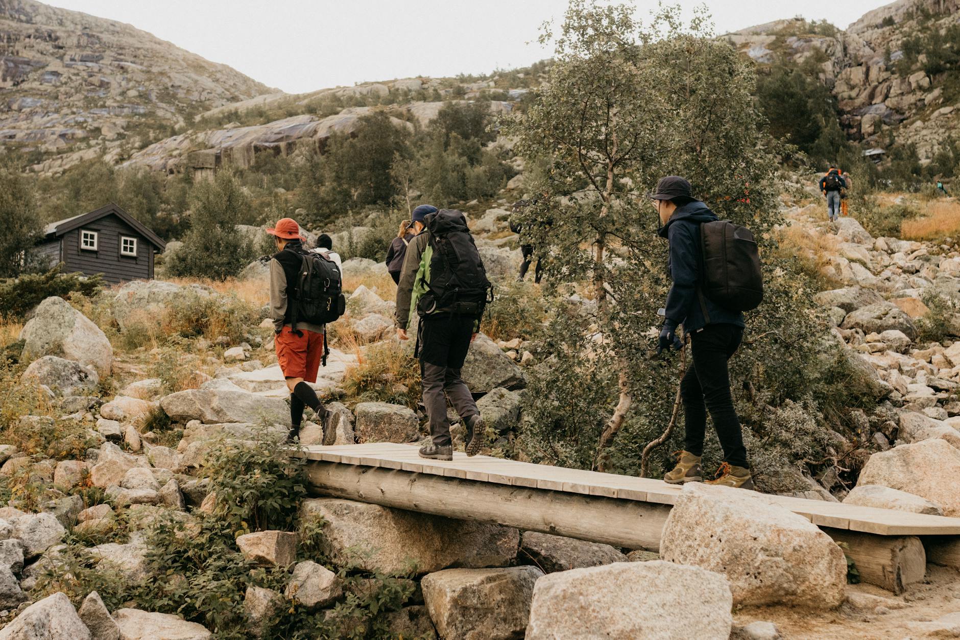 Hikers on a mountain bridge for Bergen outdoor gear planning.