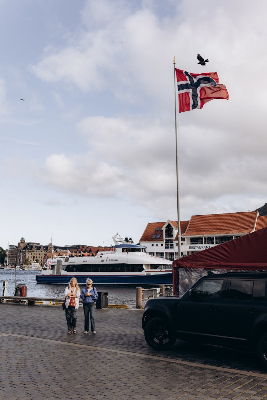 Bergen harbor ferry and Norwegian flag for port-call route planning.