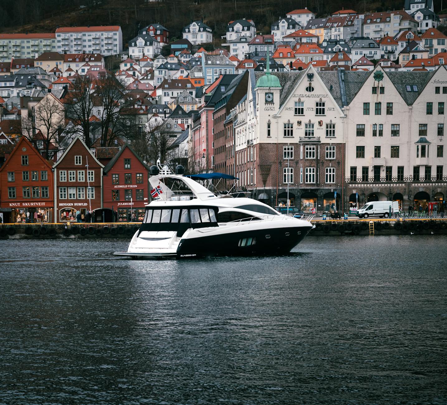 Yacht moving through Bergen harbor for luxury traveler planning.