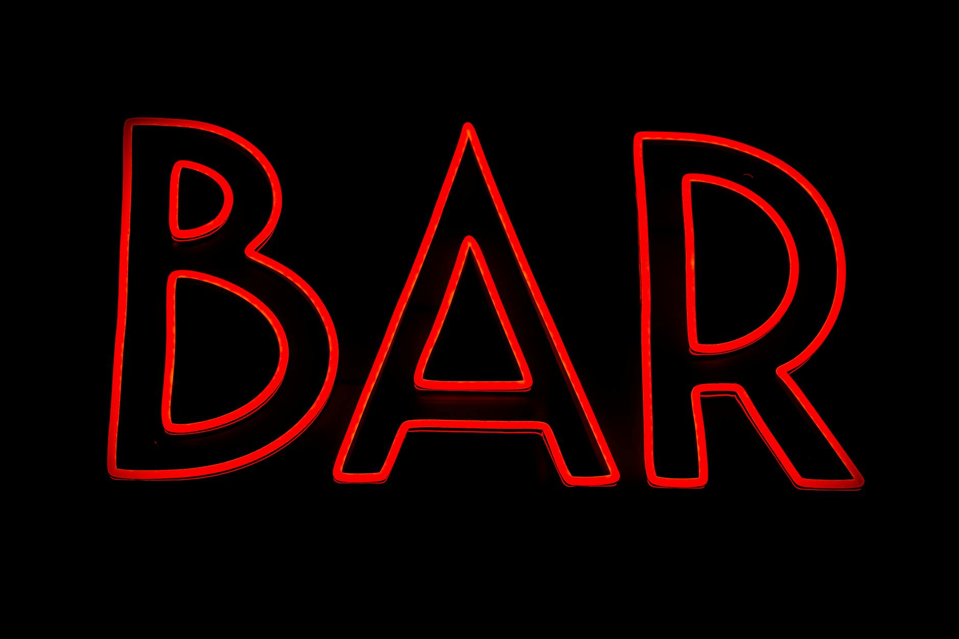 Red neon bar sign for nightlife safety and cost planning.