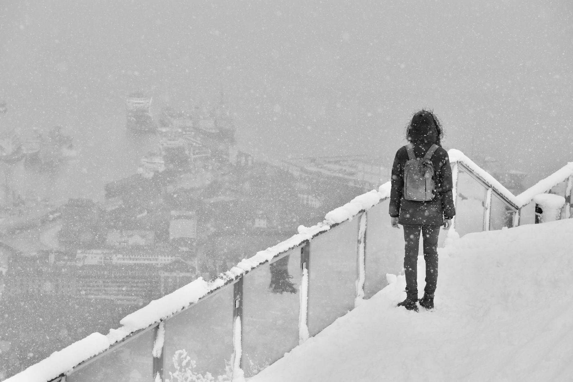 Person overlooking snowy Bergen harbor for woman traveler planning.