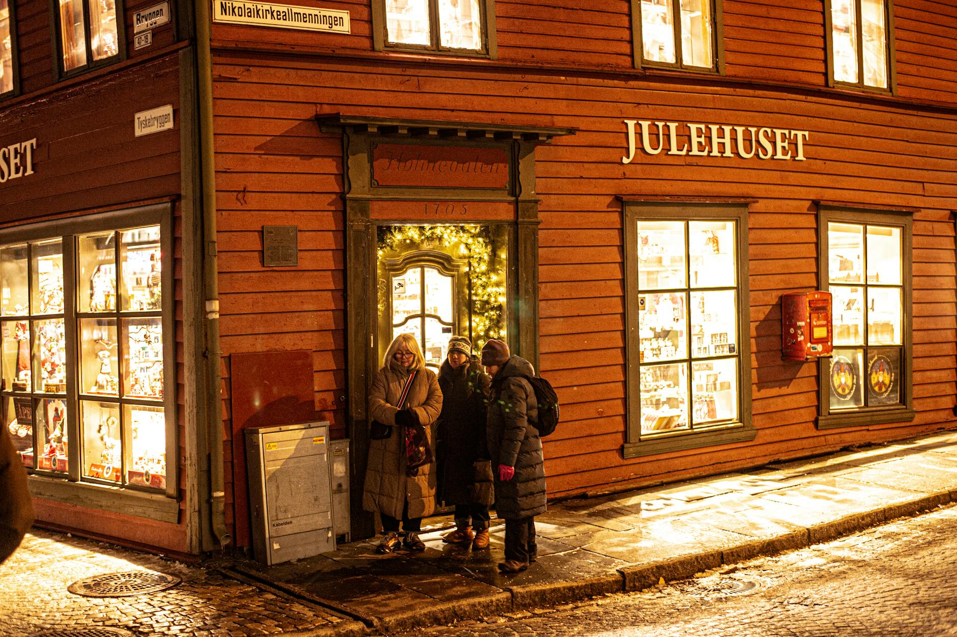 Evening outside a Bergen shop for woman traveler return planning.