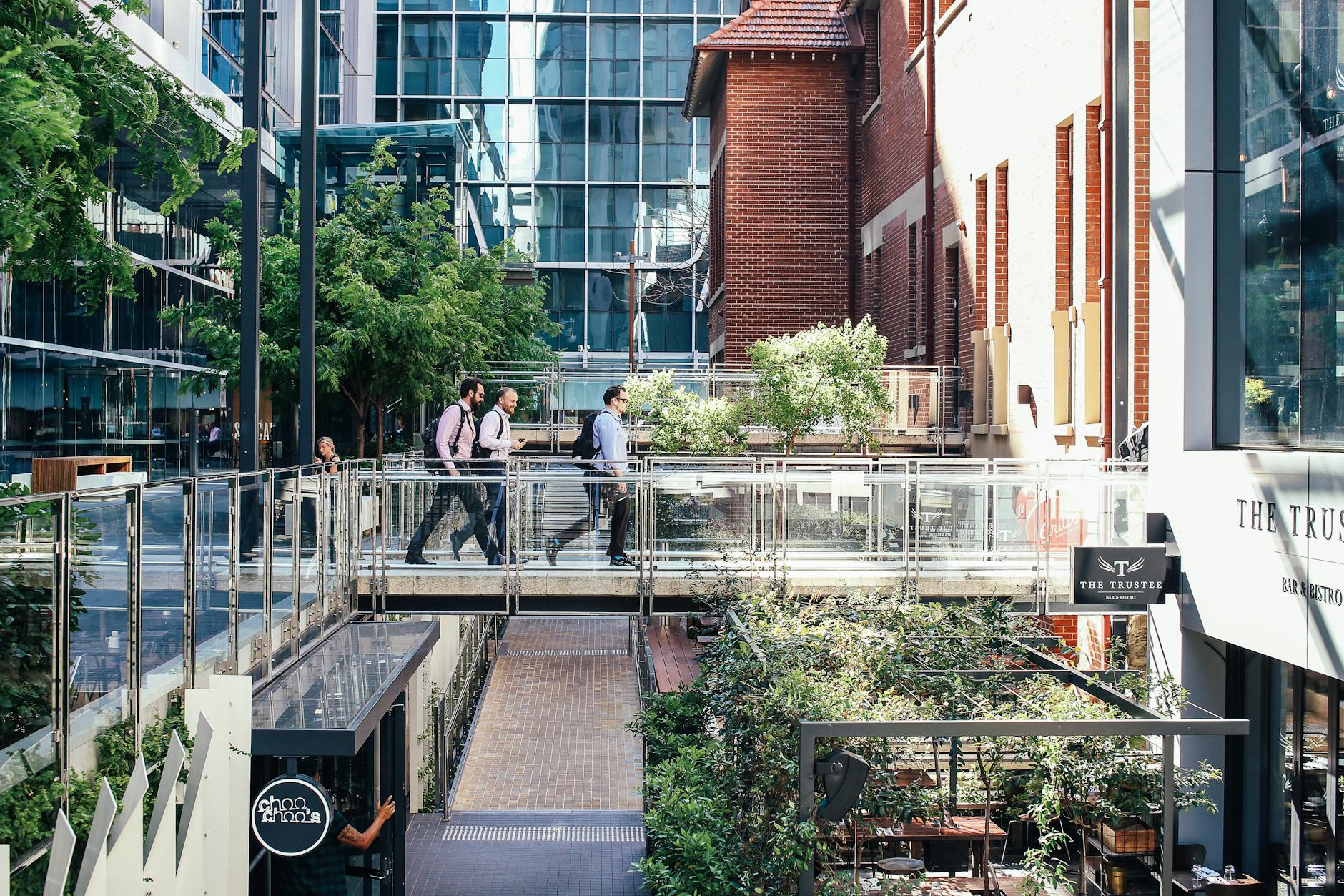 Office workers walking through a modern district for consultant hotel planning.