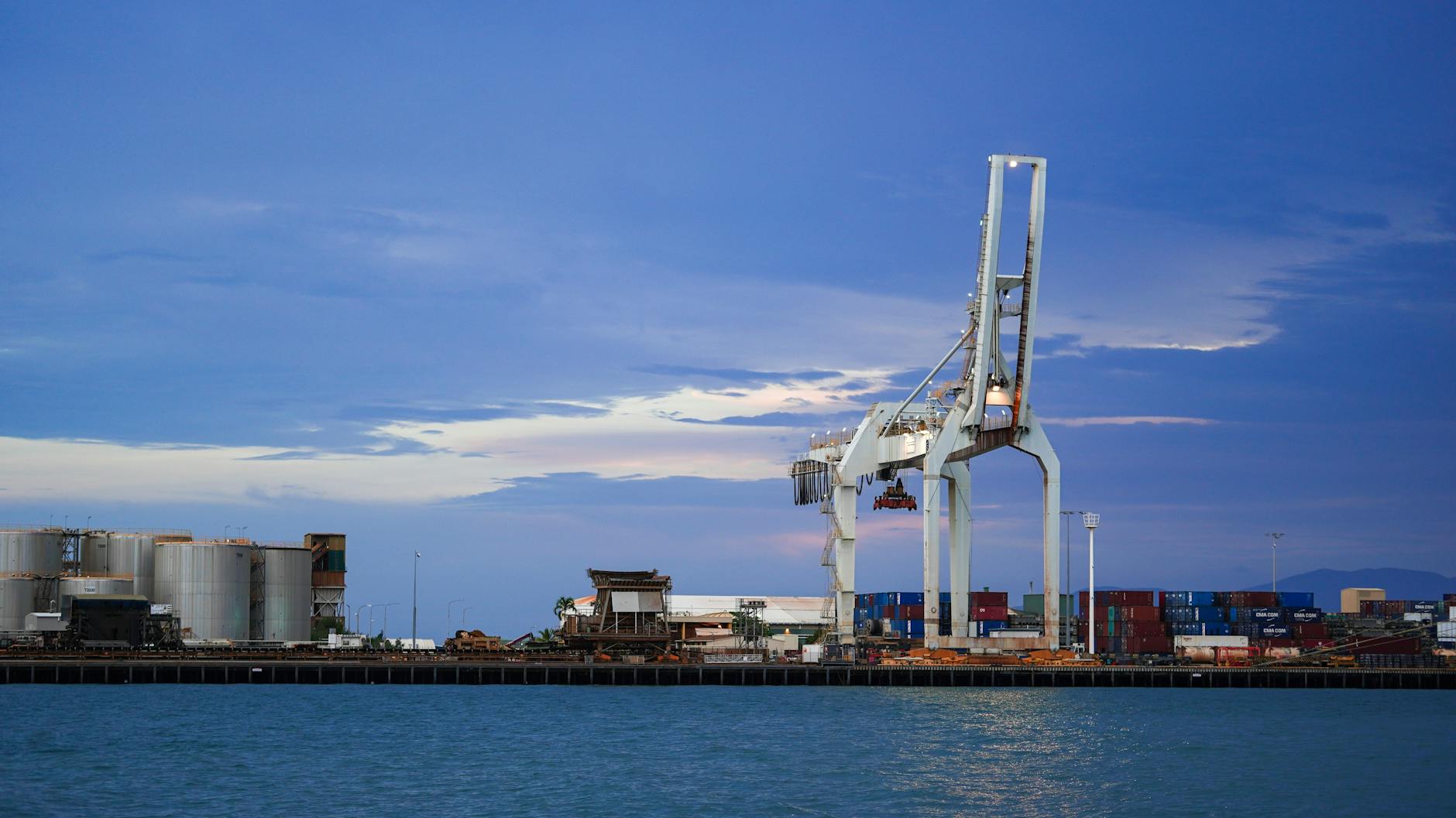 Industrial port cranes at twilight for Brisbane port weather planning.