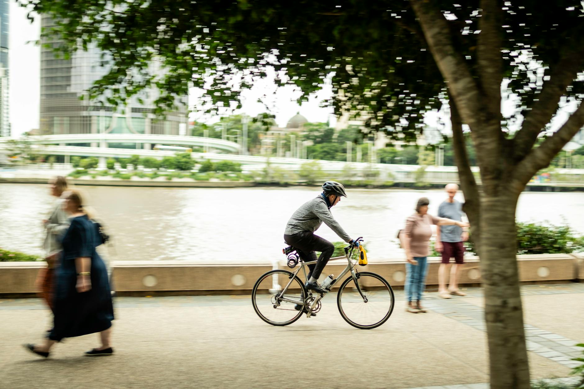 Cyclist on Brisbane riverside walkway for first-time route planning.