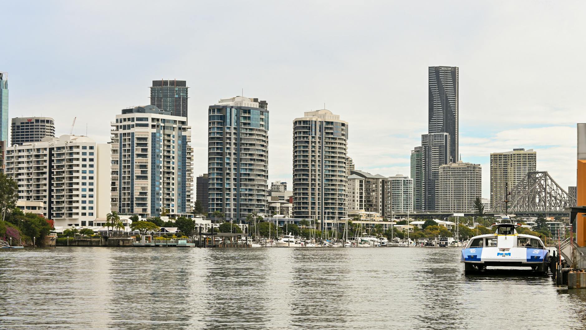 Brisbane waterfront buildings and ferry for older traveler hotel area planning.