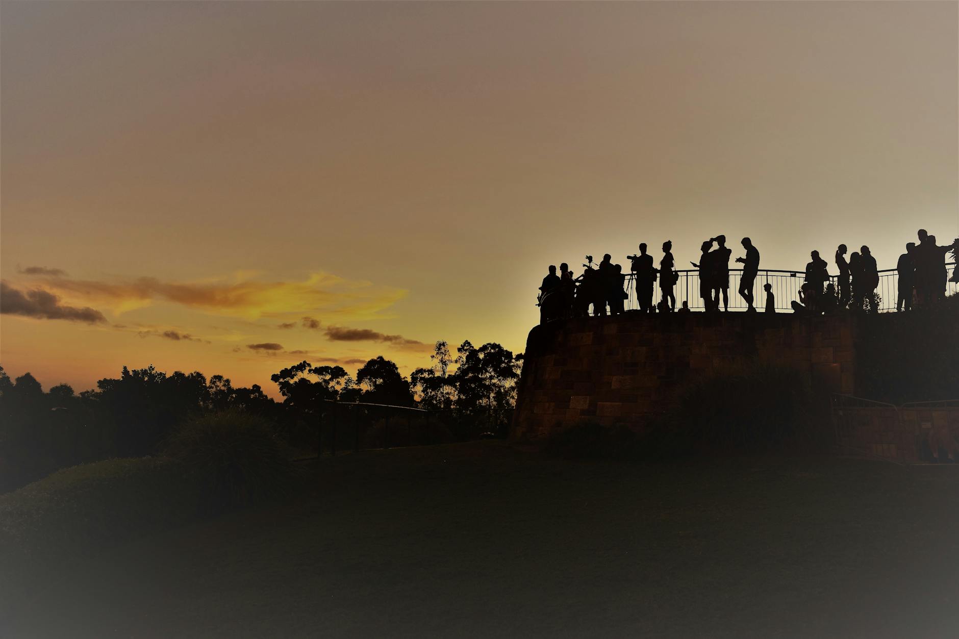 People watching sunset over Brisbane skyline for solo evening planning.