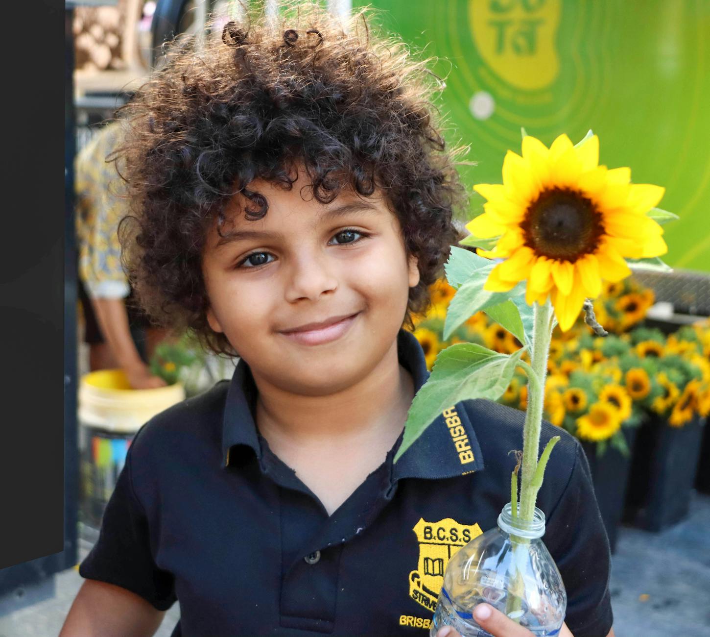 Child holding a sunflower in Brisbane for community-focused travel planning.