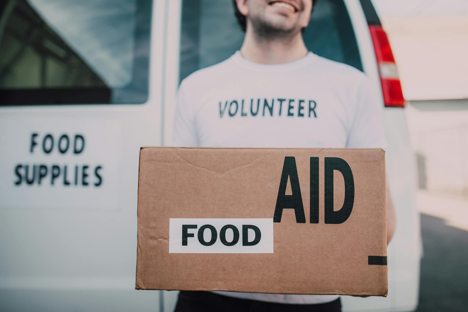 Volunteer carrying a food aid box for Brisbane NGO logistics planning.