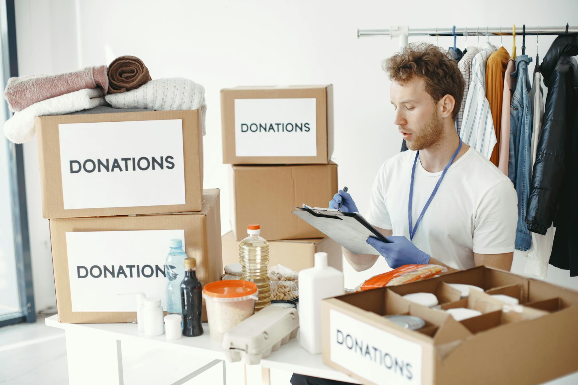 Volunteer organizing donation boxes for Brisbane partner coordination.