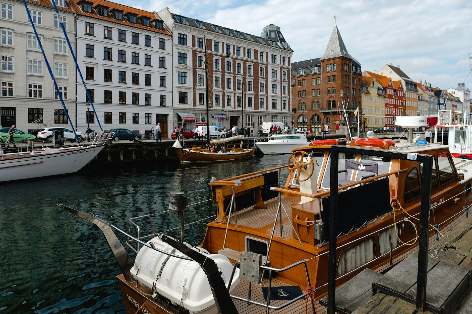 Copenhagen canal boats near cafes for port-call meal and errand planning.