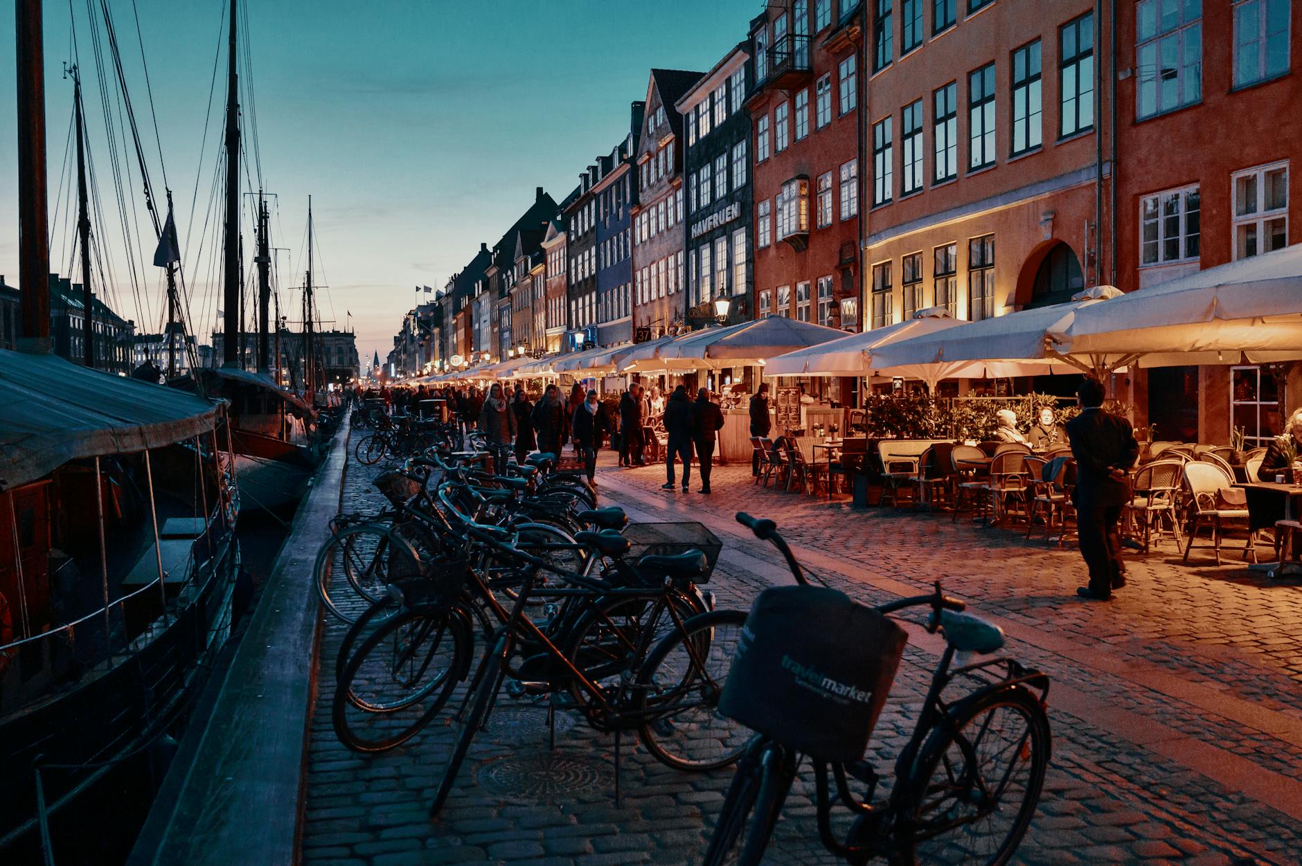 Evening bicycles and people in Nyhavn for Copenhagen nightlife planning.